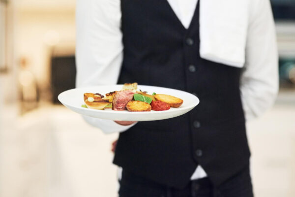 Chelner servind farfurie cu preparat gourmet