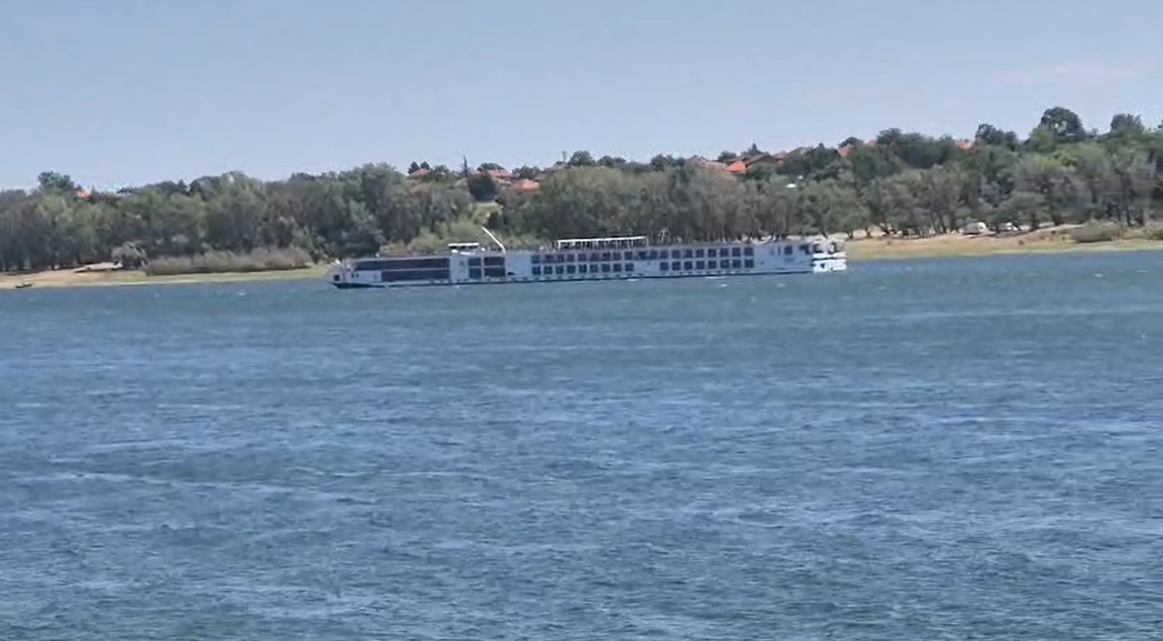 Vapor de croazieră pe râu lângă țărm împădurit