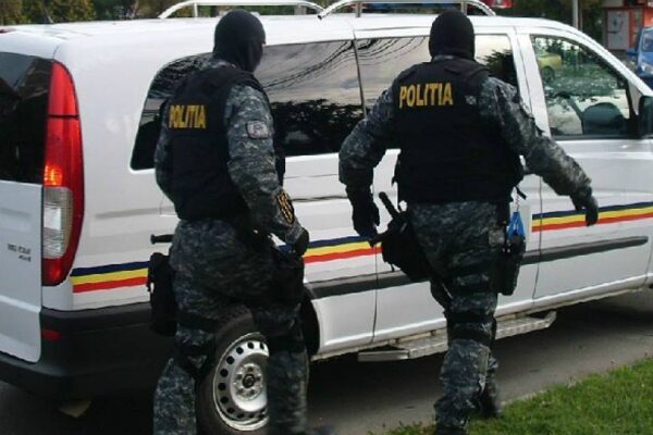 Doi polițiști lângă o dubă a Poliției Române
